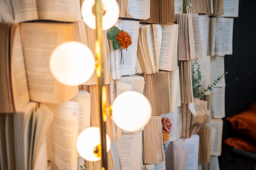 a beautiful wall of books with flowers 