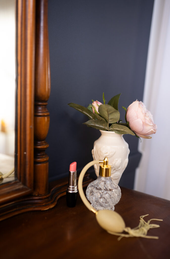 flowers, perfume and lipstick sitting on a vanity in christella boudoir an akron boudoir photographer studio